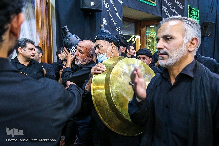 Mourners carry tubs and pots for Tasht-Gozari ritual in a mosque in Tehran in late July 2022.